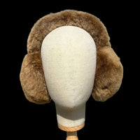 A brown fur earmuff displayed on a cream fabric mannequin head.