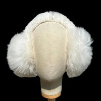 A white fur earmuff displayed on a cream fabric mannequin head.