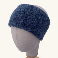 Blue knitted headband on a mannequin head against a white background
