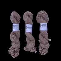 Blue skein of yarn with a label on a light gray background