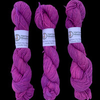 Three skeins of black yarn with labels on a white background
