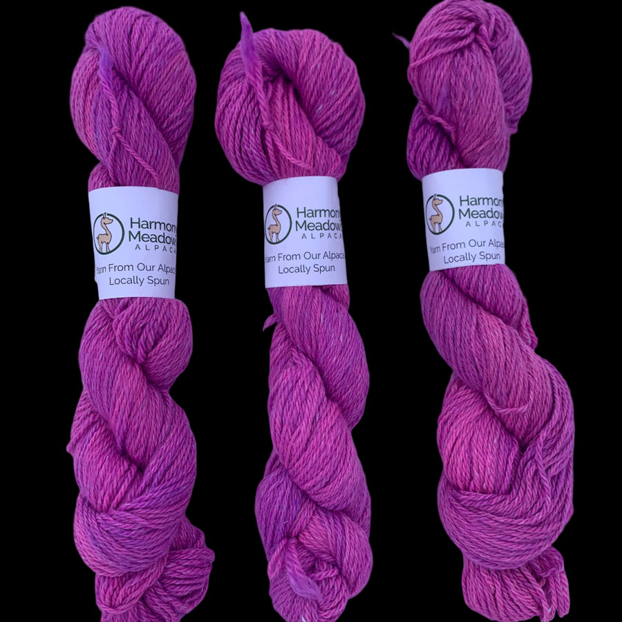 Three skeins of black yarn with labels on a white background