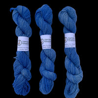 Three skeins of brown yarn with labels on a white background