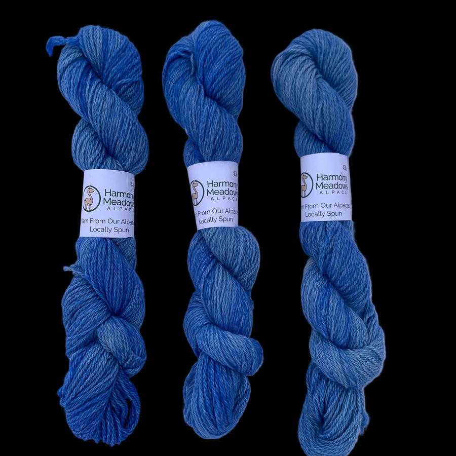 Three skeins of brown yarn with labels on a white background