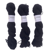 Three skeins of gray yarn with labels on a light gray background